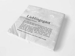 White cloth napkin with "Favorite Guest" text printed on it.