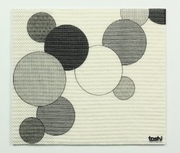 Sponge cloth with a pattern of 10 circles and 1 rectangle in various shades of gray.