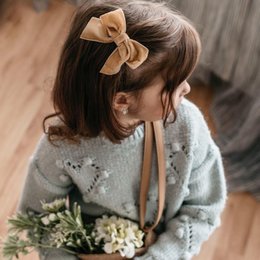 Soft, cozy baby hat with a delicate bow accent in a variety of colors including red, blue, caramel, turquoise, pink, and ivory. Perfect for keeping little ones warm and stylish.