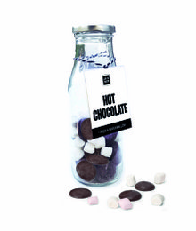 A glass jar filled with dark chocolate candies and marshmallows, accompanied by a label that reads "Hot Chocolate".