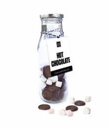 A glass jar filled with dark chocolate candies and marshmallows, accompanied by a label that reads "Hot Chocolate".