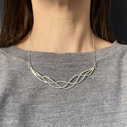 Silver tangle necklace, a delicate chain necklace with an intricate twisted design, made of silver-toned metal, suitable for casual or formal wear.