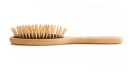 Oval bamboo hair brush with long pins for hair styling and grooming. Made of natural bamboo material, this brush features long bristles to detangle and smooth hair.
