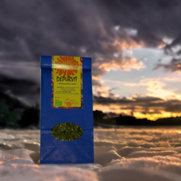Organic herbal tea in a blue box with yellow and green accents, featuring a sunset landscape in the background.
