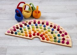 Colorful felt ball maker with rainbow-colored balls, suitable for sensory play and development.