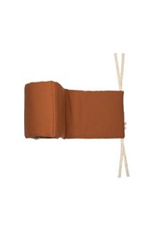 Decorative rust-colored pillow with tasseled edges, suitable for a child's room.