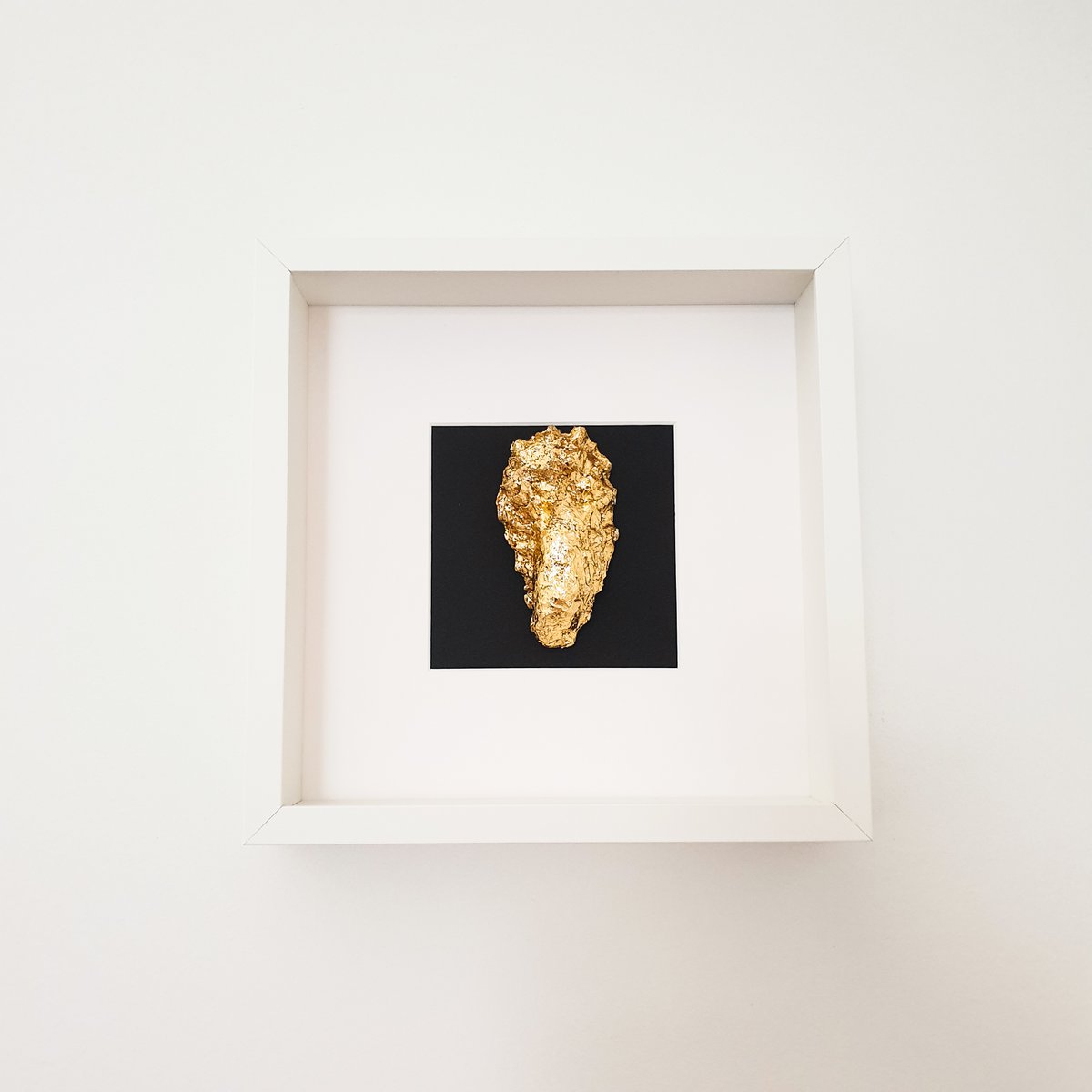 Gouden oester in houten witte lijst