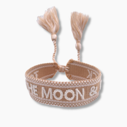 Woven bracelet with "To the Moon & Back" text and tassels in neutral colors.