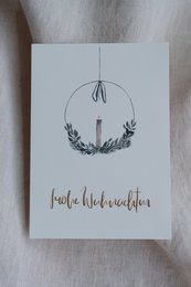 Festive Christmas postcard with a wreath design and the text "Frohe Weihnachten" (Merry Christmas) in gold foil.