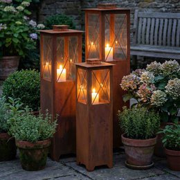 Patina metal lantern in various sizes, featuring a rustic, weathered finish and glass panels for a warm, ambient glow. Suitable for outdoor garden decor.