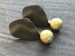 Elegant drop earrings in a sleek, modern design. Crafted with a matte black finish and accented with two small golden spheres for a touch of subtle elegance.