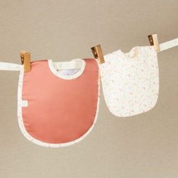  A soft, floral-patterned bib with a pink trim. The bib is made of a lightweight, absorbent material and is suitable for babies and toddlers.