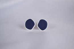 Oval-shaped stud earrings in navy blue and white colors.