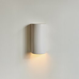 Elegant, minimalist white ceramic wall sconce with up and down lighting for a Japandi-inspired look.