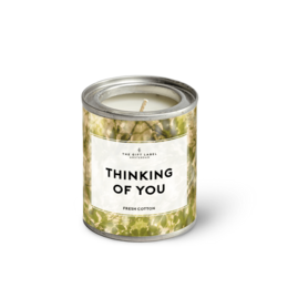  Small round candle in a glass jar with a label that says "Thinking of You - Fresh Cotton". The candle is surrounded by yellow and green floral elements.