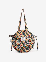 Colorful floral round shopping bag with drawstring closure and long handles.
