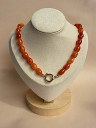 Amber beaded necklace, warm orange-red translucent stones, chunky round beads, metal clasp closure.
