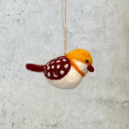 A small, decorative blue and orange bird statue or ornament, made of felt or fabric, hanging from a string.