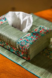 Handmade tissue box holder, green linen with colorful floral embroidered trim, rectangular shape, decorative home accessory.