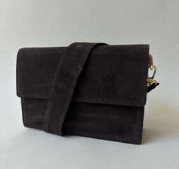 Black suede shoulder bag with flap closure and adjustable strap. Brown suede crossbody bag. Soft suede material.