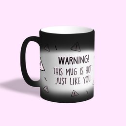 This mug features a bold warning message printed on a black and white design, with a playful triangle pattern. The text reads "WARNING! THIS MUG IS HOT JUST LIKE YOU", suggesting a humorous and cheeky tone.