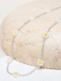 Delicate daisy chain sunglasses strap in light green color with floral accents.
