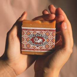 Natural handmade soap bars in various scents including honey and oat milk, pomegranate, vanilla and coffee, and coffee and cardamom. The soaps are made with 100% natural ingredients and 100% of the profits are donated.