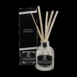 A room diffuser with a tiare flower scent, featuring a glass bottle with a black label and reed sticks for dispersing the fragrance.