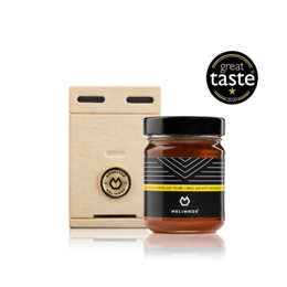 Wooden gift box containing 250g of honey from wild herbs and thyme. Honey has a rich, aromatic flavor and is packaged in a rustic, natural-looking box.