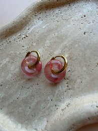Pink swirl resin stud earrings, round shape, translucent with speckled details.