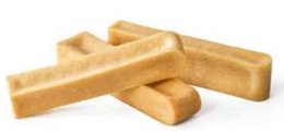 Large bulk package of pet food in the shape of rectangular biscuits or treats. The pet food appears to be made of a light golden or yellow-colored material, likely a grain-based formula.