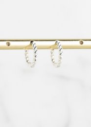 Silver twisted hoop earrings with a minimalist and elegant design.