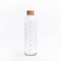 A clear glass bottle with a white and black geometric pattern design, featuring a wooden cap. The bottle appears to be a 0.7 liter travel bottle from the "Flower of Life" product line.