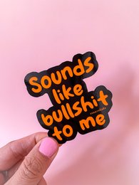 Sticker with text "Sounds like bullshit to me" in bold, colorful lettering against a pink background.