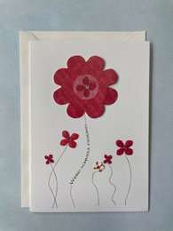 A folding get well card with a red flower design and envelope.