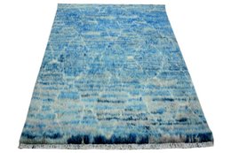 Handknotted rug in shades of blue with a textured, abstract pattern.