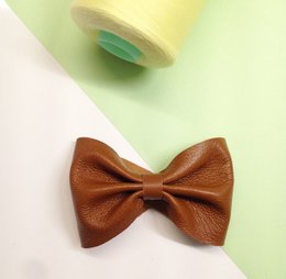 Brown leather bow tie with a plain cuff design.