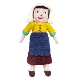 Colorful crocheted plush doll with a smiling face, wearing a yellow top, blue skirt, and brown shoes. The doll appears to be inspired by the famous painting "The Milkmaid" by Johannes Vermeer.