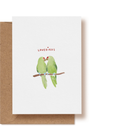 Two green lovebirds perched on a branch, illustrated on a greeting card.