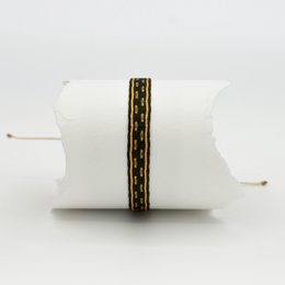 Thin bracelet with a decorative metallic band in a repeating pattern.