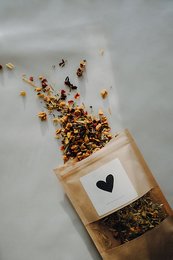 Herbal tea with a variety of flavors including 7 Sinneskräuter, Honig-Ingwer-Zitrone, and heart and thank you designs on the packaging.