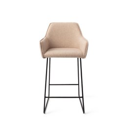  Jesper Home Hofu Barkruk Slide Black (counter) - A modern, upholstered bar stool with a sleek black metal frame and a comfortable, textured beige seat. Suitable for use at a kitchen counter or bar.