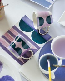  Handpainted chai mug with geometric shapes, purple and teal colors, modern abstract design, ceramic cup with handle.