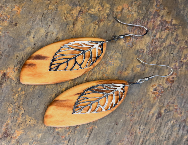 Handmade leaf-shaped earrings made of excitingly patterned olive wood with a silver pendant - natural elegance and sustainability, great grain