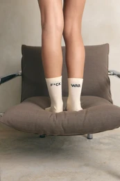 White crew socks with black text "F*ck War" message, casual unisex style.