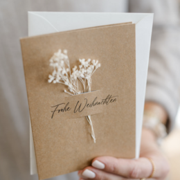 Sustainable Christmas card made of natural paper with dried flowers