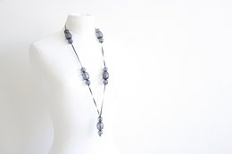 Medium-sized black necklace with silver-colored charms.