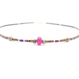 A pink jade stone pendant with hematite beads on a necklace. The necklace features a mix of colorful beads in various shapes and sizes, creating a unique and stylish accessory.