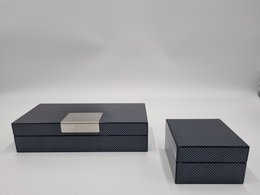 A set of two black jewelry boxes or storage boxes with a high-gloss carbon fiber-like finish. The boxes have a sleek, modern design and are suitable for storing jewelry, accessories, or other small items.