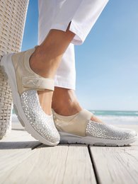  Beige, gray print, and blue women's sandals with velcro tabs and a comfortable, slip-on design. The sandals feature a textured, patterned upper and a cushioned sole for all-day wear.